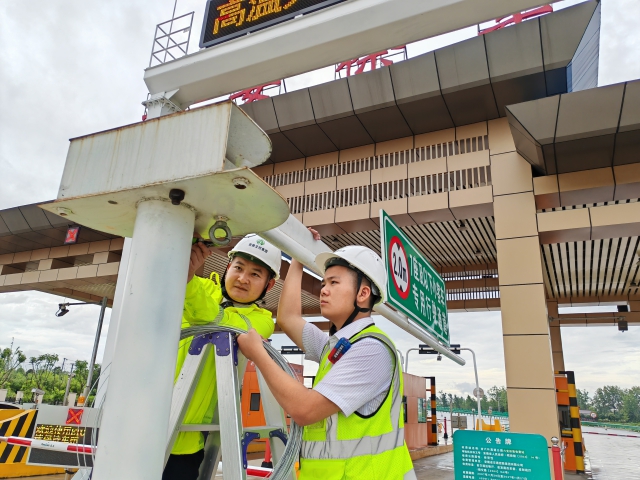 01 六安北中心六安徐集站收費員熊俊、高賀應(yīng)對臺風(fēng)“格美” 加固限高門架.png